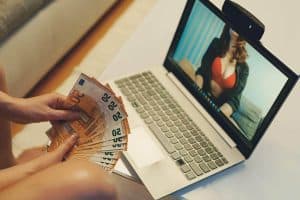 A sexy woman scamming a man for money online.