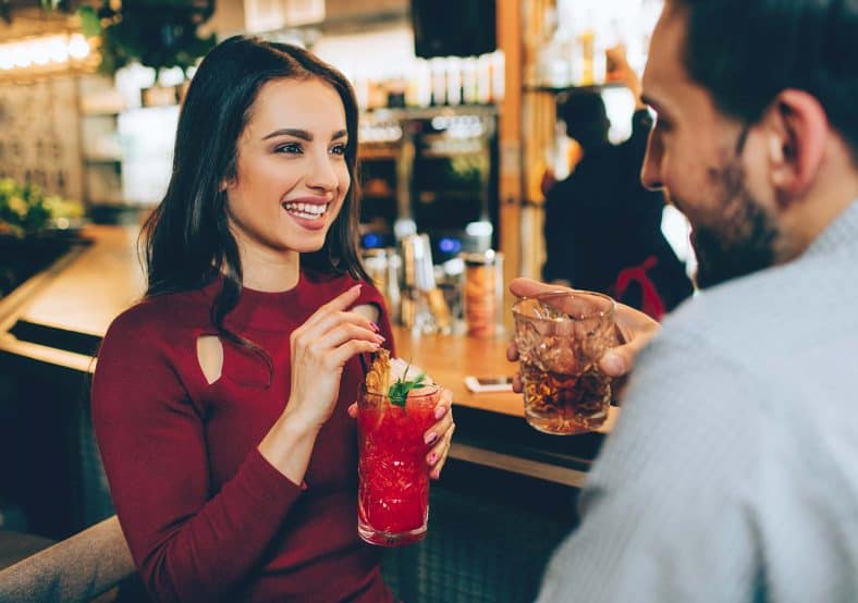 man talking to a woman at the bar