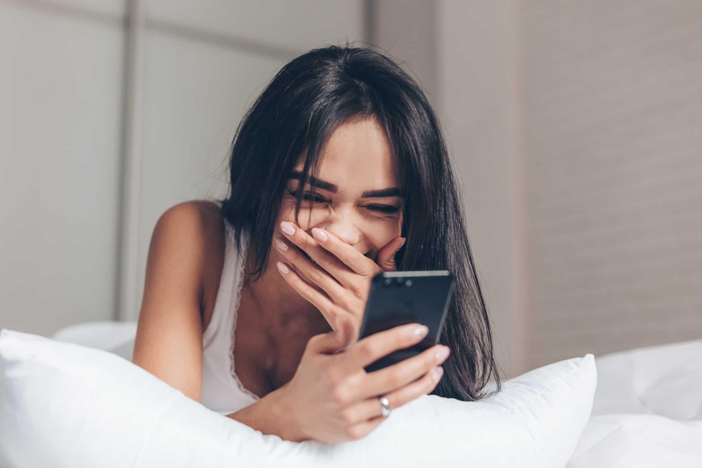 Attractive girl reading her text messages and laughing