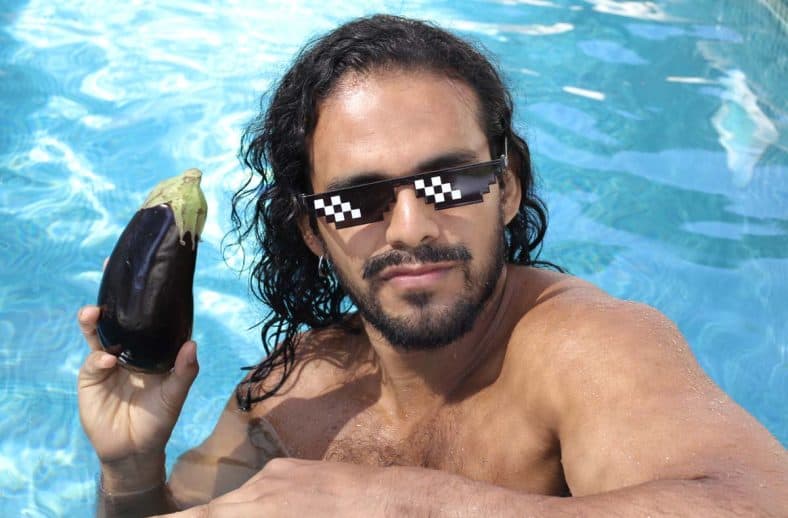 Funny photo of a man holding an eggplant.